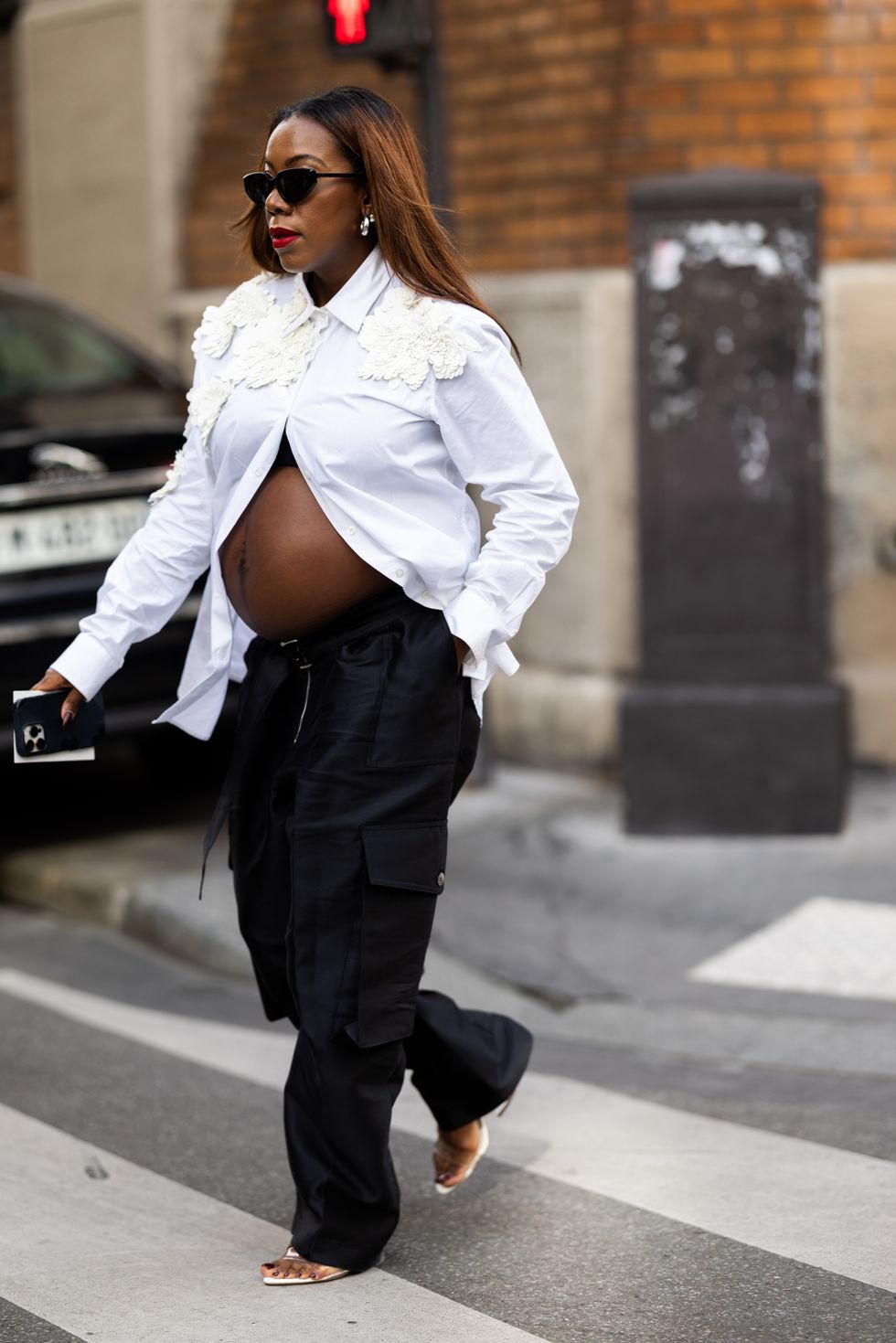 A guest is seen wearing a white button shirt with embellishment and cargo pants outside Dries Van Noten show during the Womenswear Spring/Summer 2024 as part of Paris Fashion Week