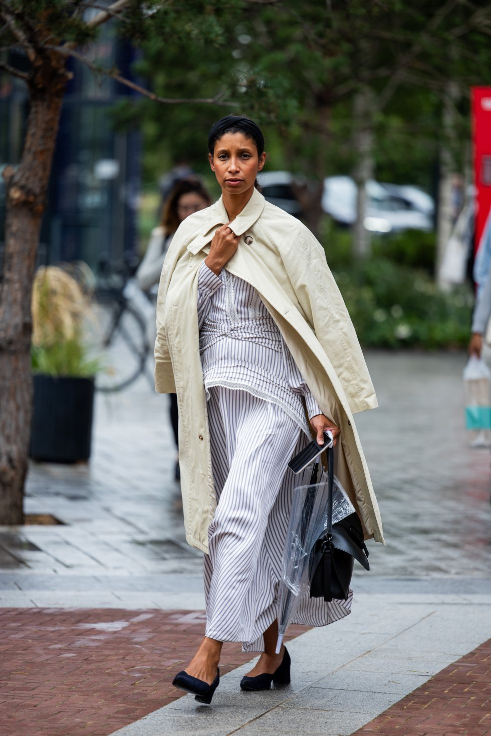 A guest is seen wearing white striped skirt, top, trench coat outside Simone Rocha during London Fashion Week September 2023