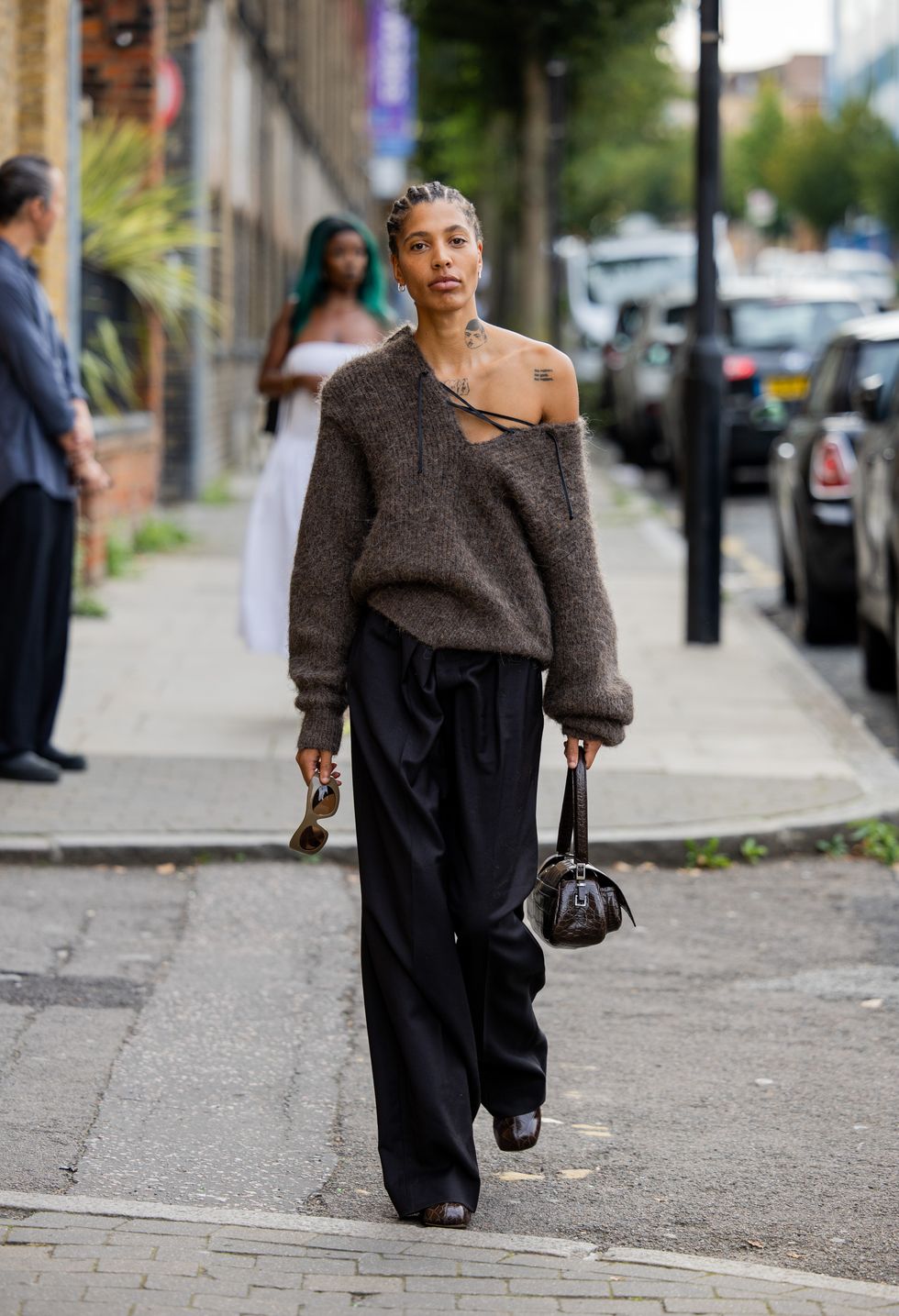 A guest wears brown knit, black bag, pants outside 16Arlington during London Fashion Week September 2023