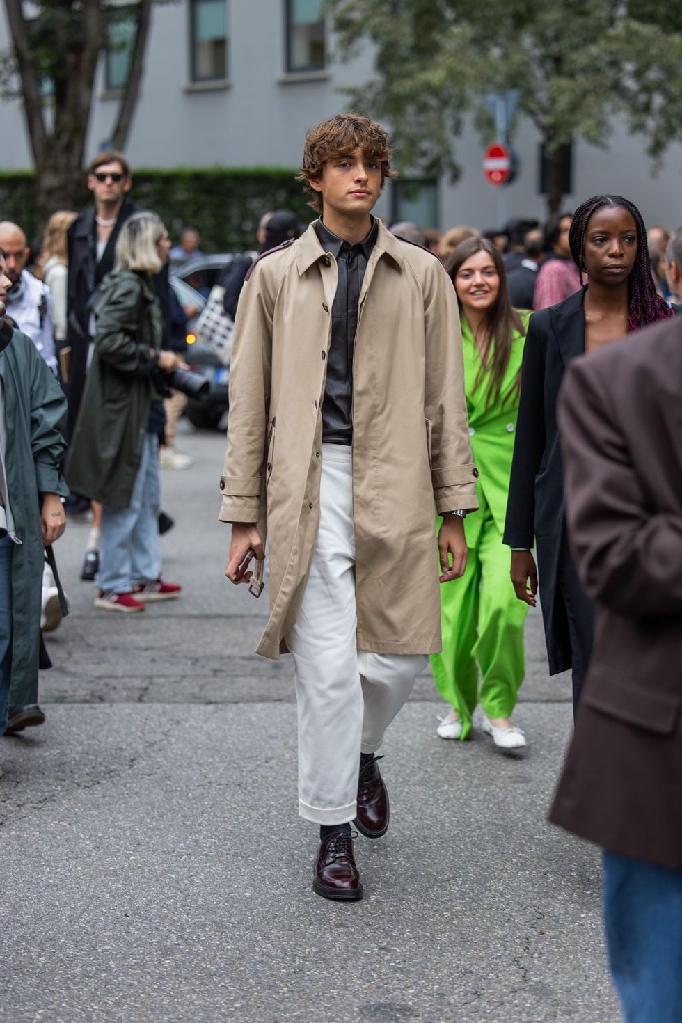 A guest wears trench coat outside Tods during the Milan Fashion Week