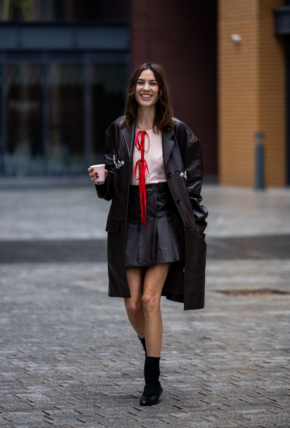 Alexa Chung is seen wearing brown mini skirt, coat outside Simone Rocha during London Fashion Week September 2023